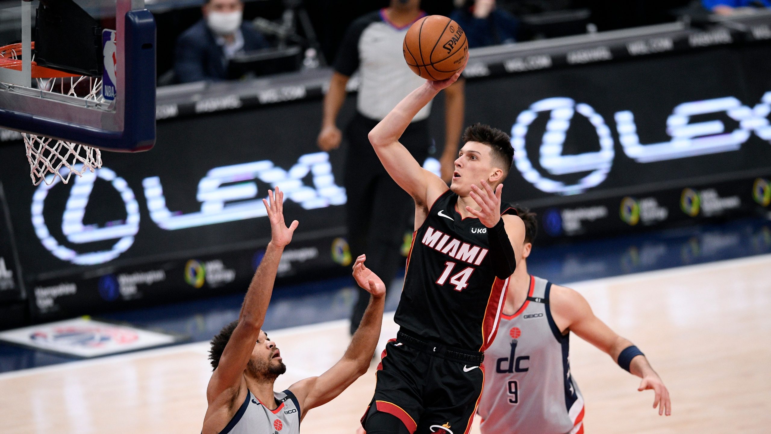 Miami Heat guard Tyler Herro (14) shoots between Washington Wizards guard Jerome Robinson (12) and forward Deni Avdija (9) during the second half of an NBA basketball game. (Nick Wass/AP)