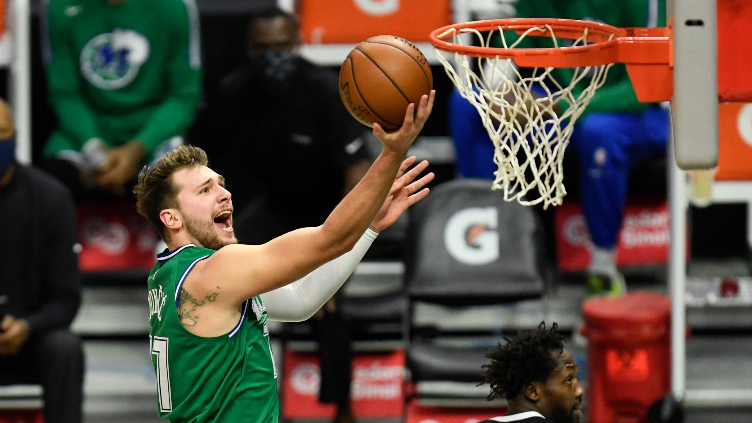 Dallas Mavericks guard Luka Doncic, left, goes up for a basket past Los Angeles Clippers guard Patrick Beverley during the first half of an NBA basketball game. (Kyusung Gong/AP)
