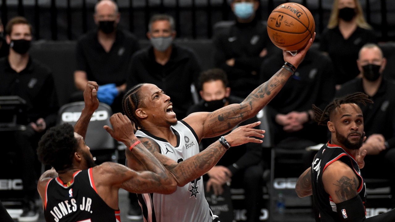 San Antonio Spurs forward DeMar DeRozan, right, drives to the basket against Portland Trail Blazers forward Derrick Jones Jr., left, during the second half of an NBA basketball game. (Steve Dykes/AP)