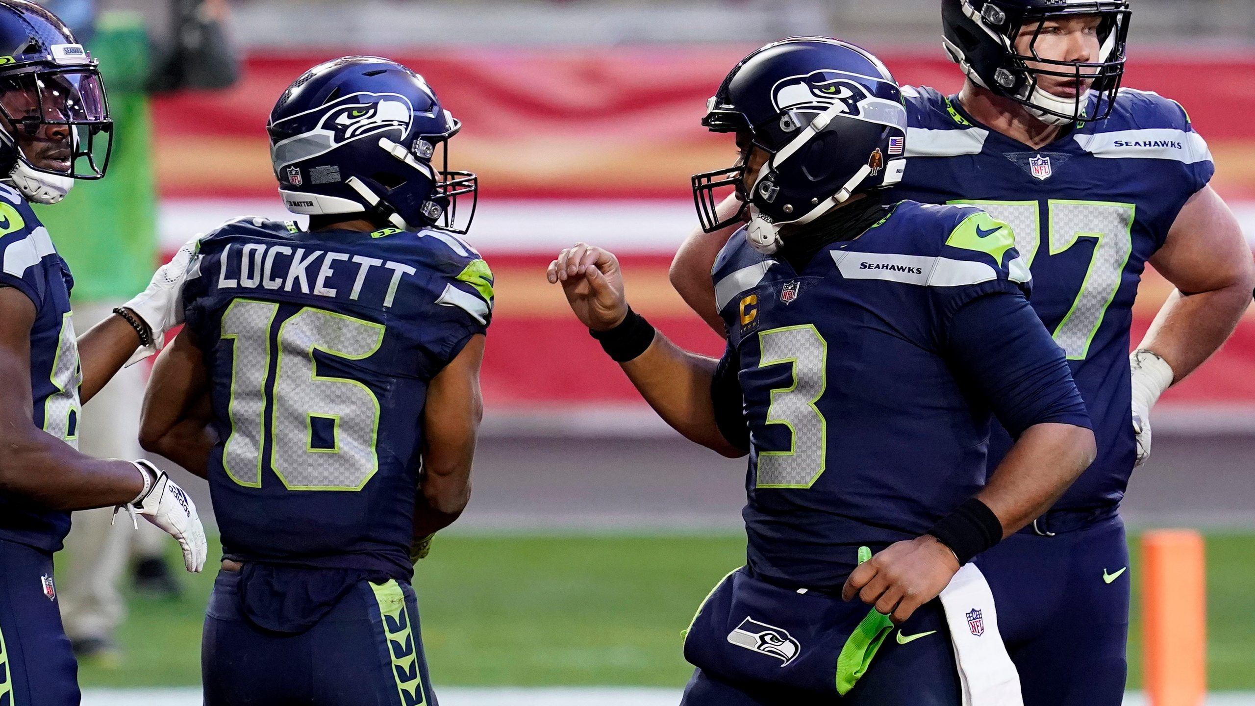 Seattle Seahawks wide receiver Tyler Lockett (16) celebrates his touchdown with quarterback Russell Wilson (3) during the second half of an NFL football game against the San Francisco 49ers. (Ross D. Franklin/AP)