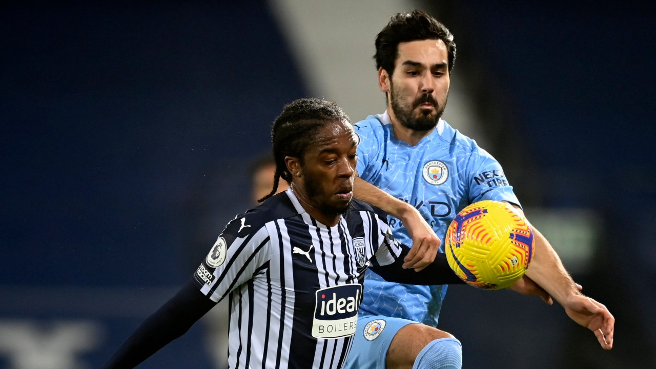 West Bromwich Albion's Romaine Sawyers, front, duels for the ball with Manchester City's Ilkay Gundogan during the English Premier League soccer match between West Bromwich Albion and Manchester City at the Hawthorns stadium in West Bromwich, England, Tuesday, Jan. 26, 2021. (Michael Regan/Pool via AP)