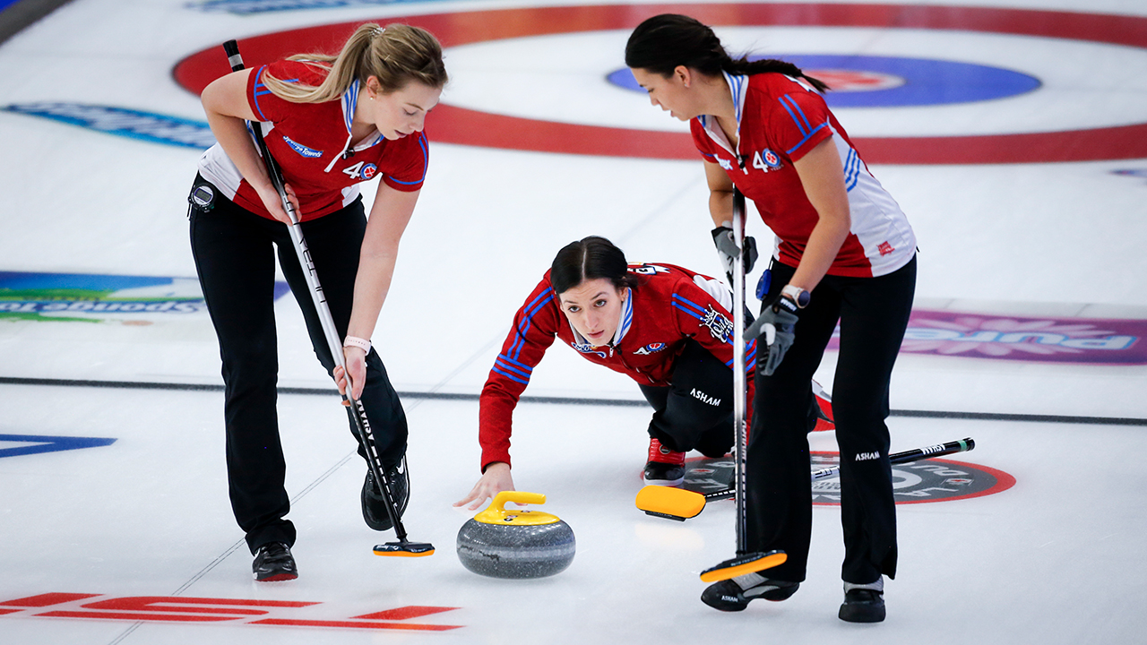 Team Wild Card 3 skip Beth Peterson, centre, makes a shot against Team Northwest Territories as second Katherine Doerksen, left, and lead Brittany Tran sweep at the Scotties Tournament of Hearts in Calgary, Alta., Thursday, Feb. 25, 2021. (Jeff McIntosh/CP)