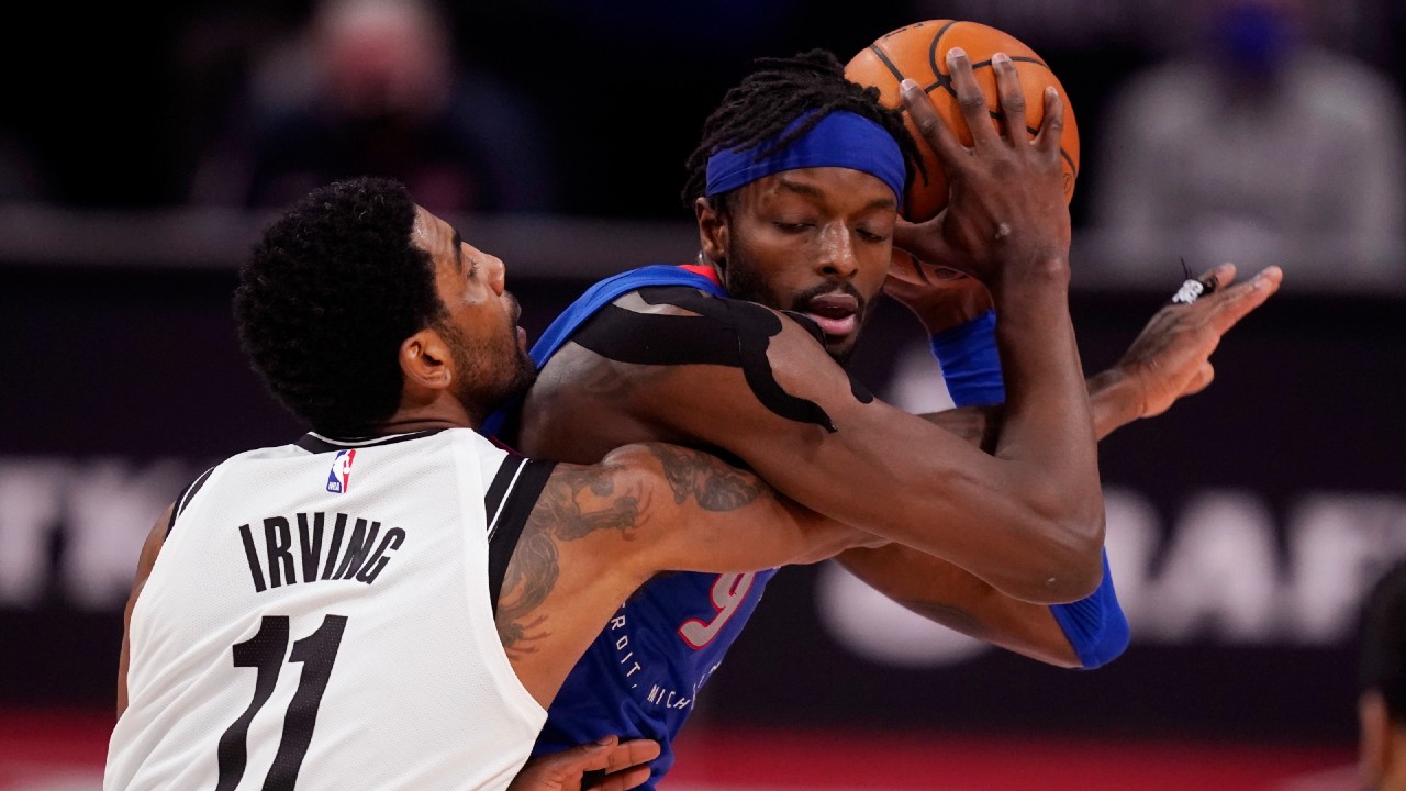 Brooklyn Nets guard Kyrie Irving (11) reaches in on Detroit Pistons forward Jerami Grant during the second half of an NBA basketball game, Tuesday, Feb. 9, 2021, in Detroit. (Carlos Osorio/AP)