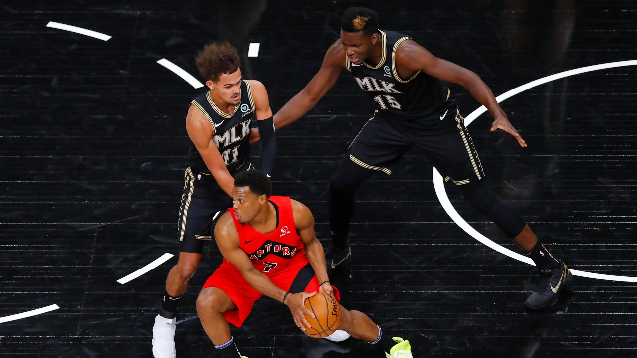 Toronto Raptors guard Kyle Lowry (7) is defended by Atlanta Hawks' Trae Young (11) and and Clint Capela (15) during the first half of an NBA basketball game. (Todd Kirkland/AP)