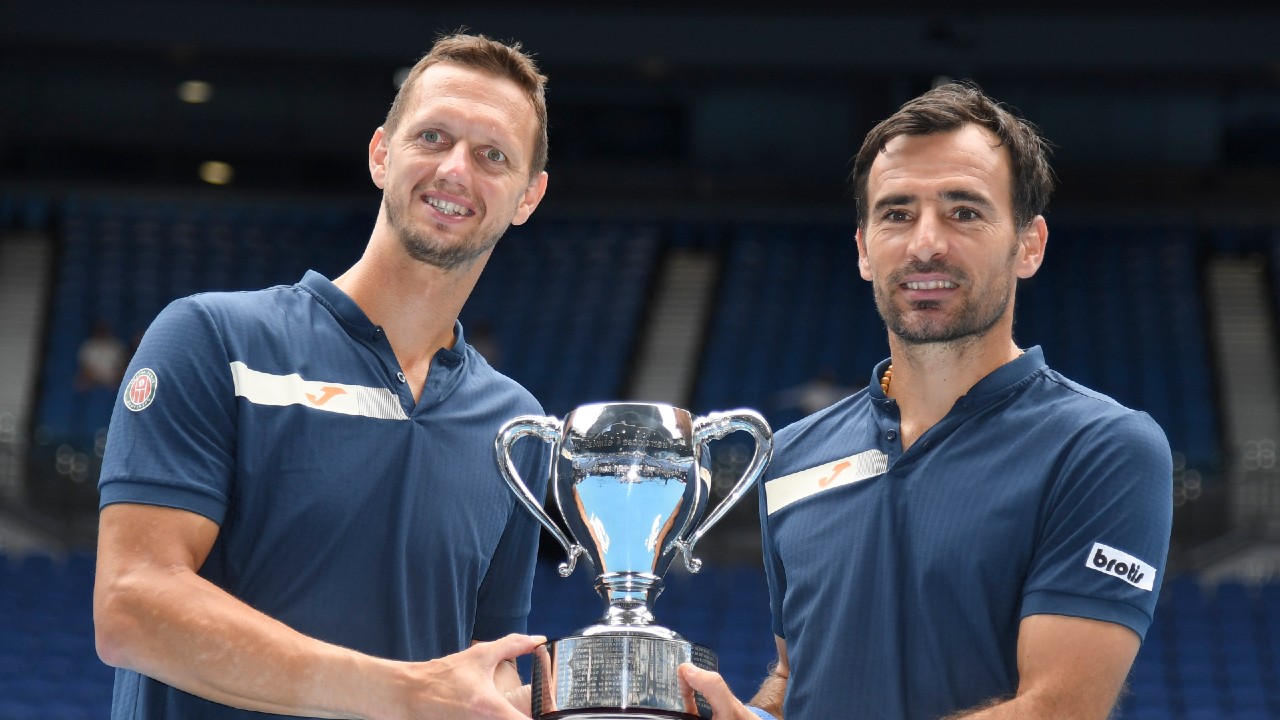 Croatia's Ivan Dodig, right, and Slovakia's Filip Polasek pose with their trophy after defeating Rajeev Ram of the US and Britain's Joe Salisbury in the men's doubles final at the Australian Open tennis championship in Melbourne, Australia, Sunday, Feb. 21, 2021. (Andy Brownbill/AP)