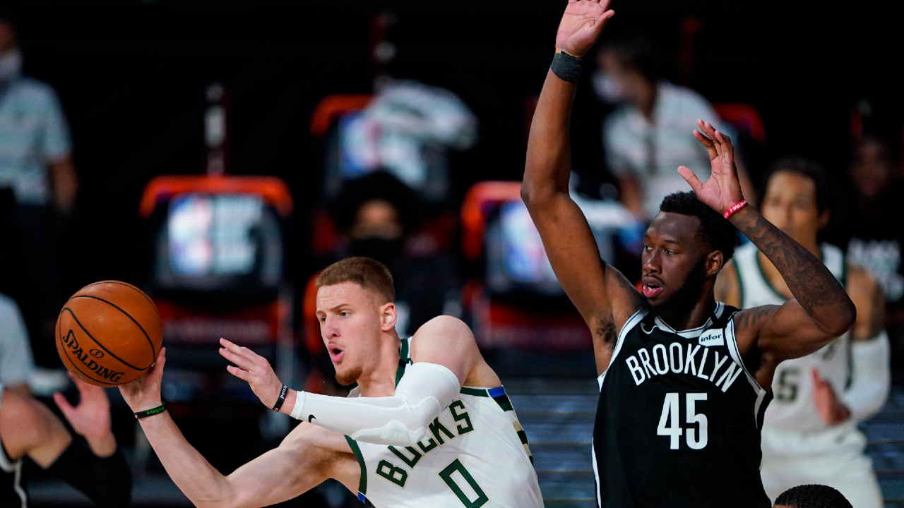 Milwaukee Bucks guard Donte DiVincenzo (0) makes a pass in front of Brooklyn Nets forward Donta Hall (45) during the second half of an NBA basketball game Tuesday, Aug. 4, 2020 in Lake Buena Vista, Fla. (Ashley Landis/AP)