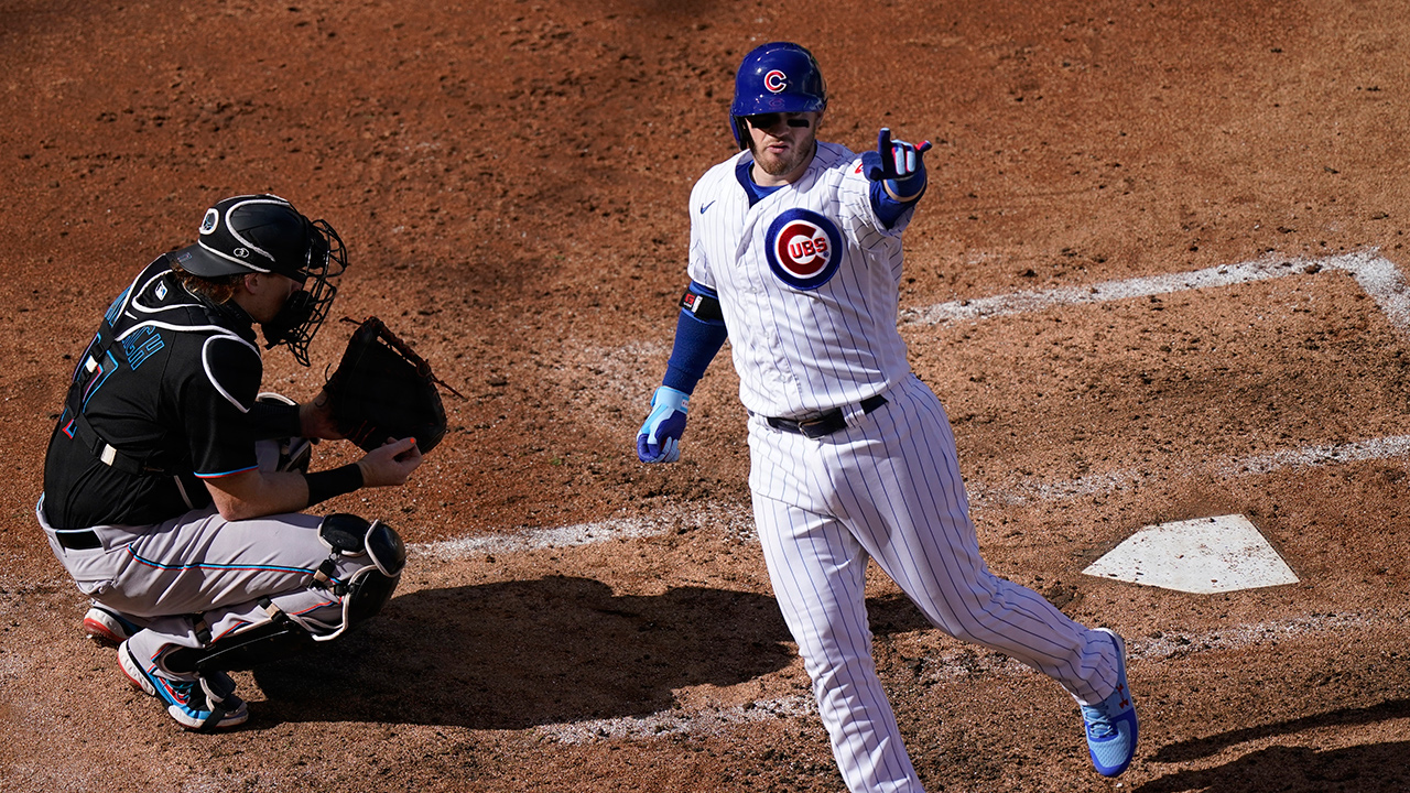 Miami Marlins catcher Chad Wallach, left, kneels by the plate as Chicago Cubs' Ian Happ, right, celebrates his solo home run in the fifth inning of Game 1 of a National League wild-card baseball series in Chicago, Wednesday, Sept. 30, 2020. (Nam Y. Huh/AP)