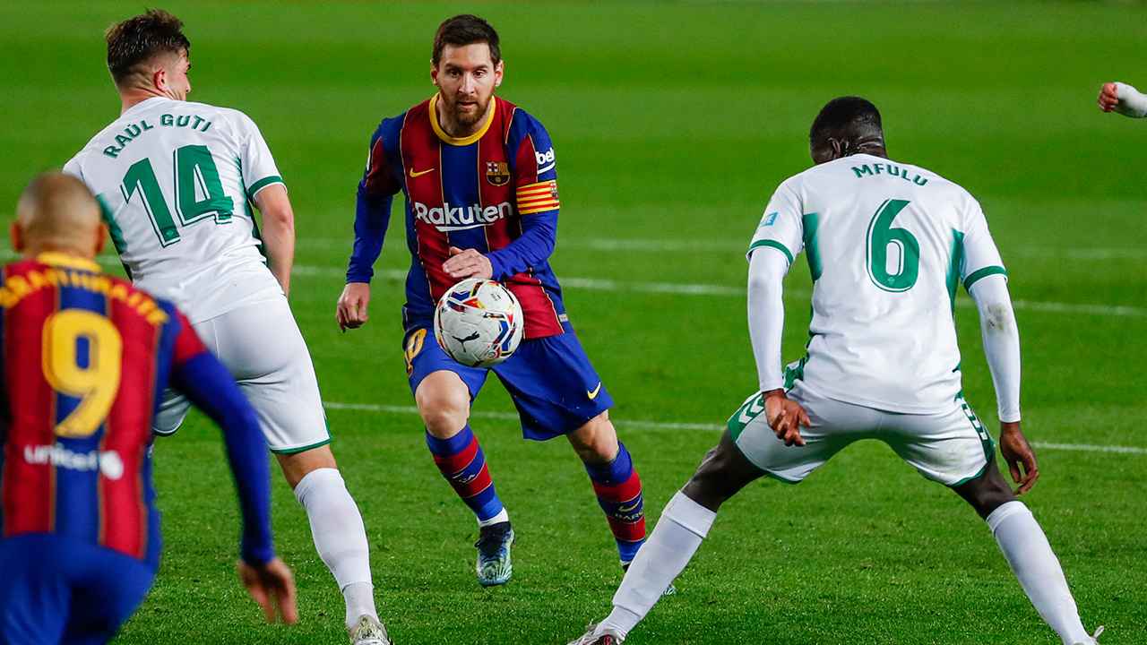 Barcelona's Lionel Messi, centre, views for the ball during the Spanish La Liga soccer match between FC Barcelona and Elche at the Camp Nou stadium in Barcelona, Spain, Wednesday, Feb. 24, 2021. (Joan Monfort/AP)