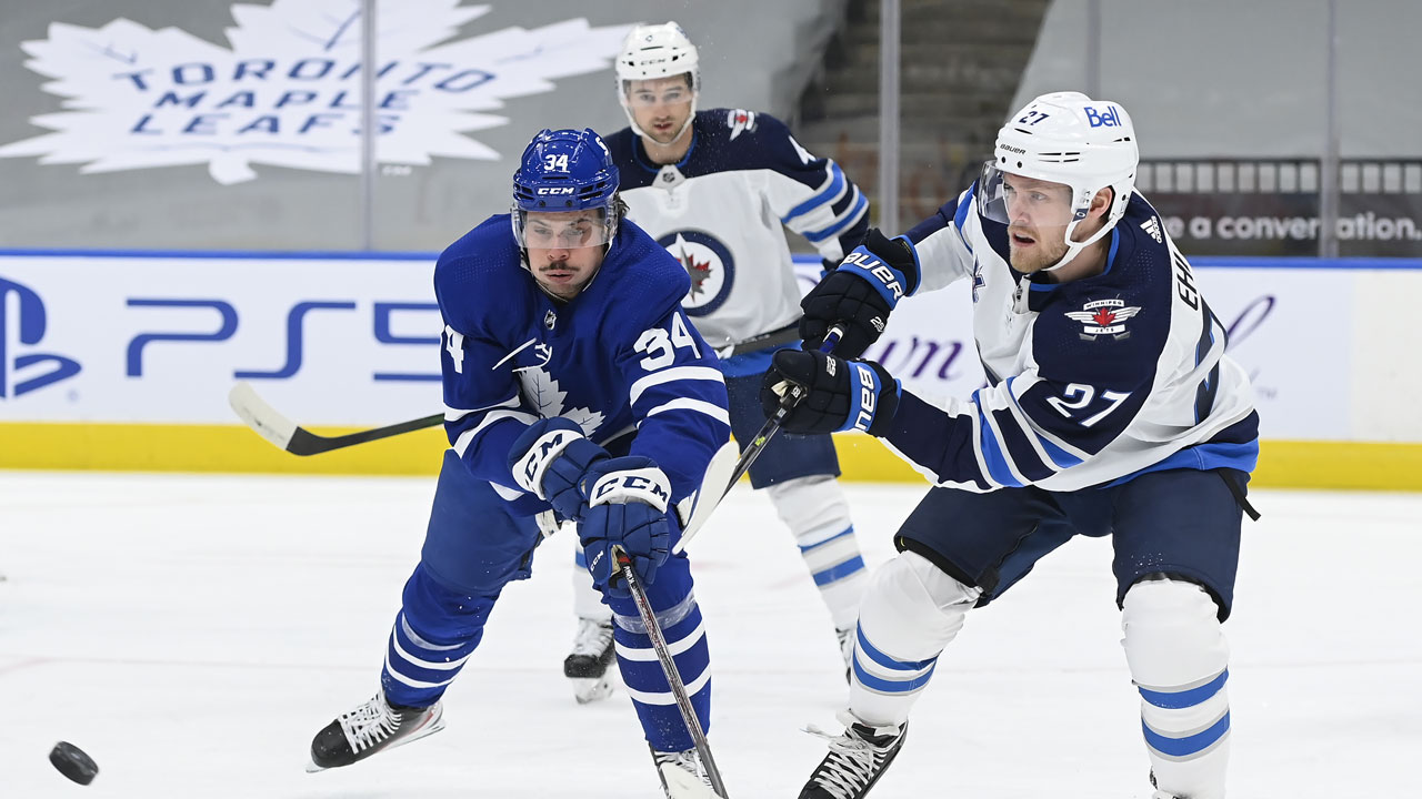 Toronto Maple Leafs centre Auston Matthews (34) battles for the puck against Winnipeg Jets left wing Nikolaj Ehlers (27) during first period NHL hockey action. (Nathan Denette/CP)
