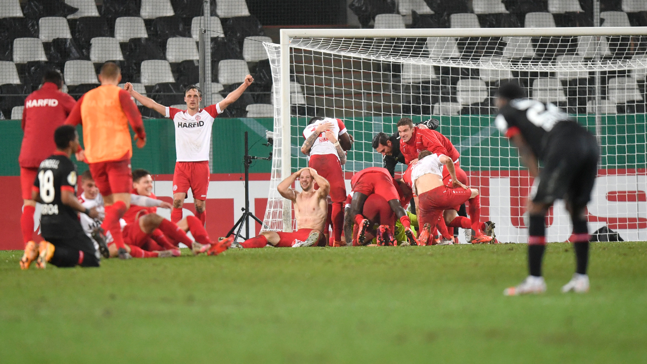 Essen's players celebrate at the end of the German Soccer Cup 3rd round match between RW Essen and Bayer Leverkusen in Essen, Germany, Tuesday, Feb. 2, 2021. (Martin Meissner, Pool/AP)