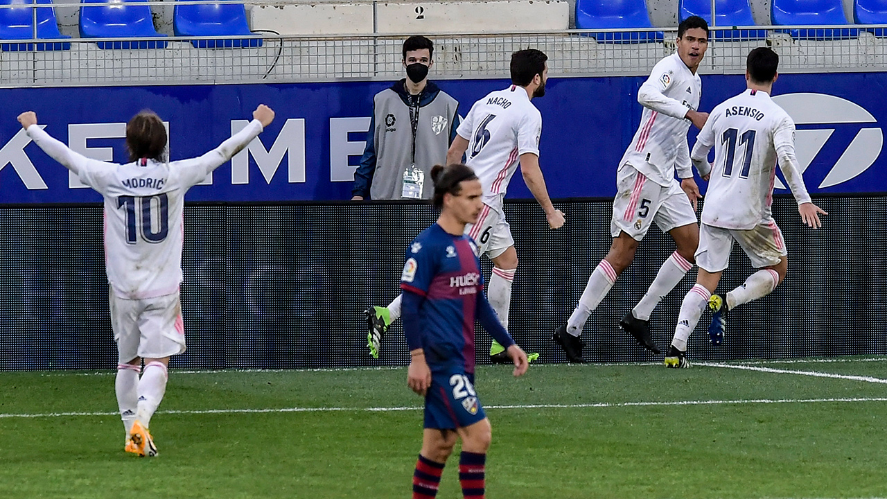 Real Madrid's Raphael Varane, right, celebrates after scoring his side's second goal during the Spanish La Liga soccer match between Huesca and Real Madrid at El Alcoraz stadium in Huesca, Spain, Saturday, Feb. 6, 2021. (Alvaro Barrientos/AP)