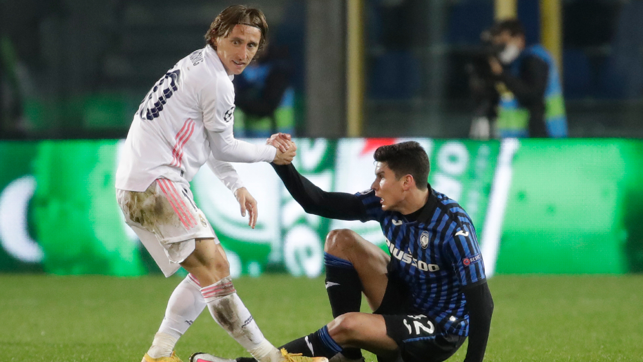 Real Madrid's Luka Modric, left, helps Atalanta's Matteo Pessina during the Champions League, round of 16, first leg soccer match between Atlanta and Real Madrid, at the Gewiss Stadium in Bergamo, Wednesday, Feb. 24, 2021. (AP Photo/Luca Bruno)