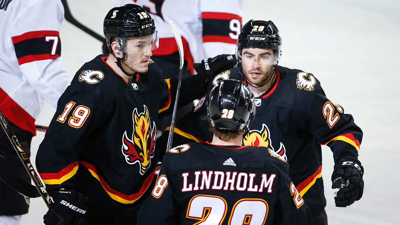 Calgary Flames' Dillon Dube, right, celebrates his goal with teammates Matthew Tkachuk, left, and Elias Lindholm during first period NHL hockey action against the Ottawa Senators in Calgary, Thursday, March 4, 2021. (Jeff McIntosh/CP)