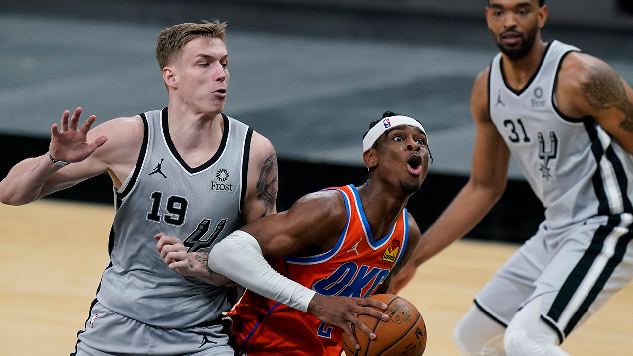 Oklahoma City Thunder guard Shai Gilgeous-Alexander (2) drives past San Antonio Spurs forward Luka Samanic (19) during the second half of an NBA basketball game in San Antonio, Thursday, March 4, 2021. (Eric Gay/AP)
