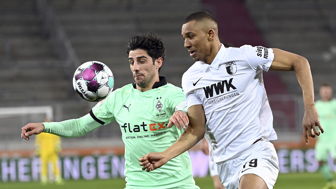 Augsburg's Felix Uduokhai, right, and Moenchengladbach's Lars Stindl fight for the ball during the German Bundesliga soccer match between FC Augsburg and Borussia Moenchengladbach. (Matthias Balk/dpa via AP)