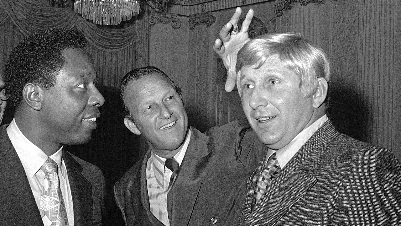 Stan Musial, center, vice president of the St. Louis Cardinals, jokes around as he reaches to feel a blond wig worn by Joe Cunningham, right, manager of the Cardinals, as Atlanta Braves' Hank Aaron, left, watches in St. Petersburg, Fla. (Fred Waters/AP)