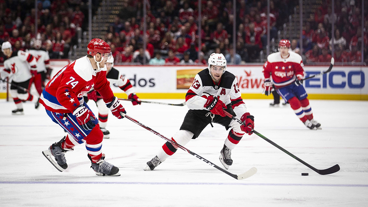 New Jersey Devils center Nico Hischier (13), from Switzerland, moves the puck past Washington Capitals defenseman John Carlson (74) during the third period of an NHL hockey game Saturday, Jan. 11, 2020, in Washington. (Al Drago/AP)