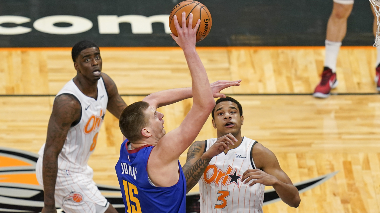 Denver Nuggets center Nikola Jokic (15) makes a shot as he gets between Orlando Magic guard Dwayne Bacon. (John Raoux/AP)