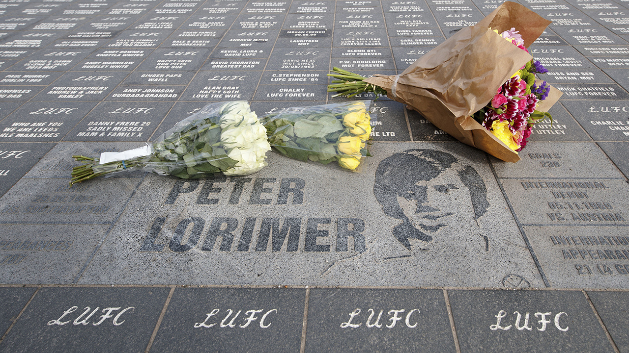 Floral tributes are seen outside Elland Road stadium following the death of Leeds' all-time record goalscorer Peter Lorimer, in Leeds, England, Saturday, March 20, 2021. (Danny Lawson/PA via AP)