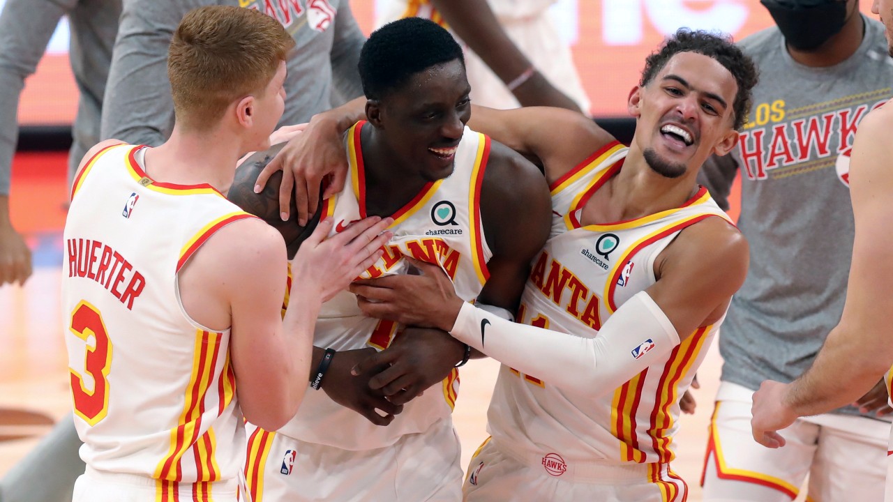 Atlanta Hawks' Tony Snell, center, is congratulated by Kevin Huerter (3) and Trae Young after his basket at the buzzer that gave the team a 121-120 win over the Toronto Raptors in an NBA basketball game. (Mike Carlson/AP)