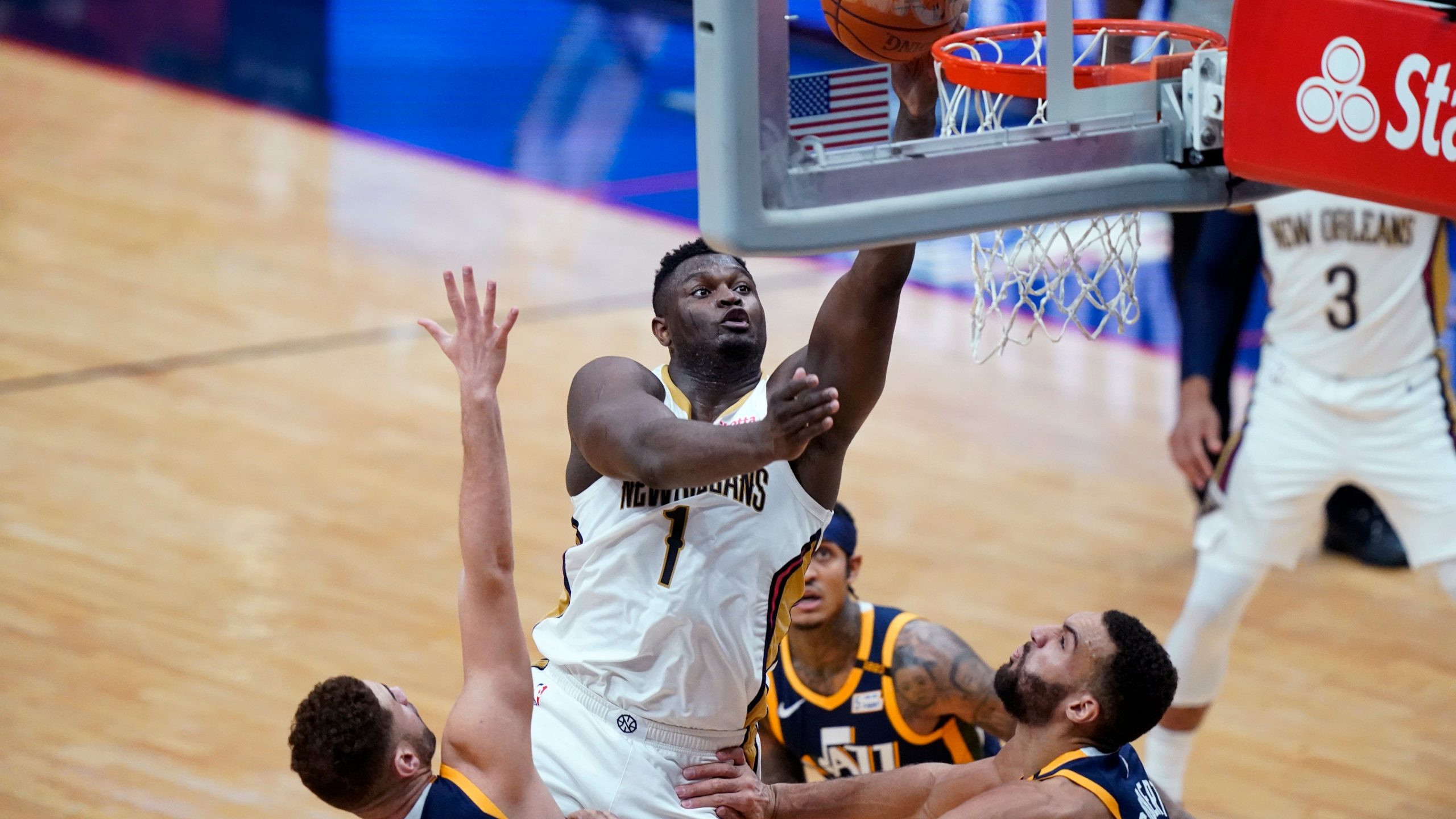 New Orleans Pelicans forward Zion Williamson (1) goes to the basket over Utah Jazz forward Georges Niang, left, and center Rudy Gobert, right, in the first half of an NBA basketball game. (Gerald Herbert/AP)