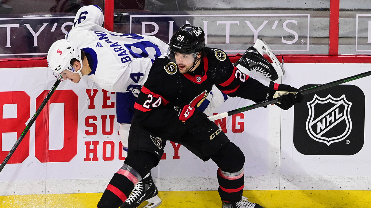 Ottawa Senators defenceman Christian Wolanin (24) pushes Toronto Maple Leafs left wing Alexander Barabanov (94) into the boards during first period NHL action in Ottawa, Friday, Jan. 15, 2021. (Sean Kilpatrick/CP)