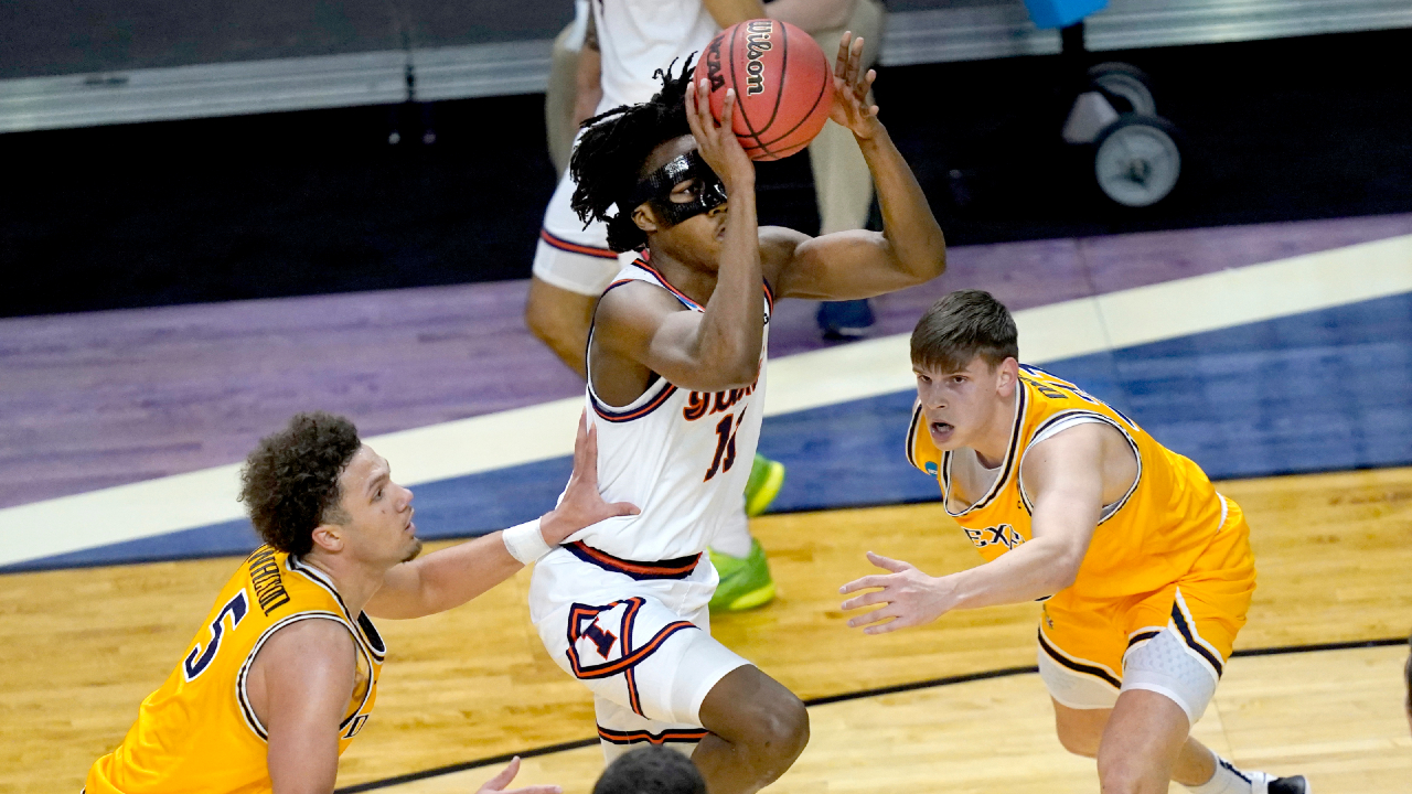 Illinois guard Ayo Dosunmu, center, drives past Drexel's Zach Walton (5) and Mate Okros, during the first half of a first round NCAA college basketball tournament game Friday, March 19, 2021, at the Indiana Farmers Coliseum in Indianapolis .(Charles Rex Arbogast/AP)
