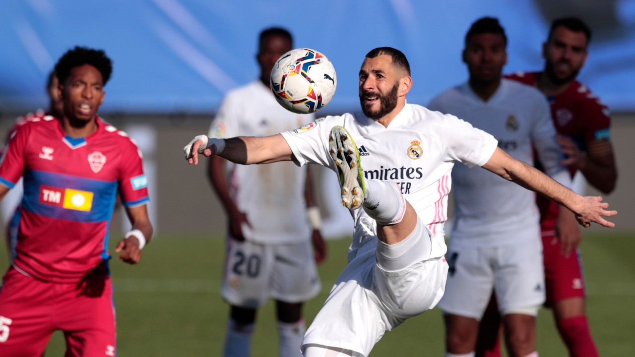 Real Madrid's Karim Benzema jumps for the ball during the Spanish La Liga soccer match between Real Madrid and Elche at the Alfredo di Stefano stadium in Madrid, Spain, Saturday, March 13, 2021. (Bernat Armangue/AP)