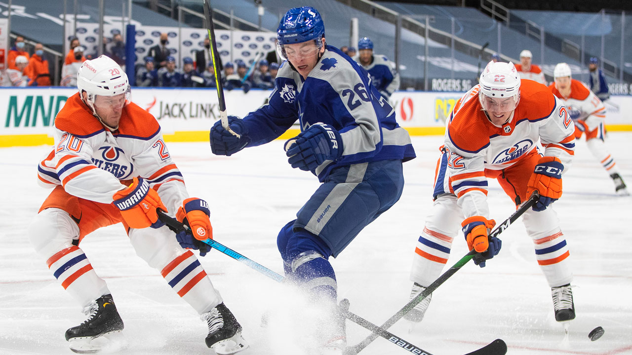 Edmonton Oilers' Slater Koekkoek (20) and Tyson Barrie (22) battle for the puck with Toronto Maple Leafs' Jimmy Vesey (26) during first period NHL action. (Jason Franson/CP)