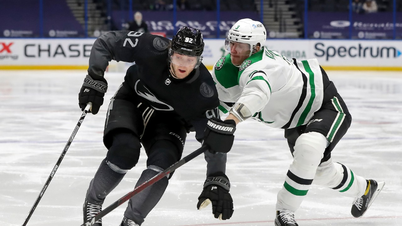 Tampa Bay Lightning's Alexander Volkov, left, fends off a check by Dallas Stars' John Klingberg during the second period of an NHL hockey game Saturday, Feb. 27, 2021, in Tampa, Fla. (Mike Carlson/AP)