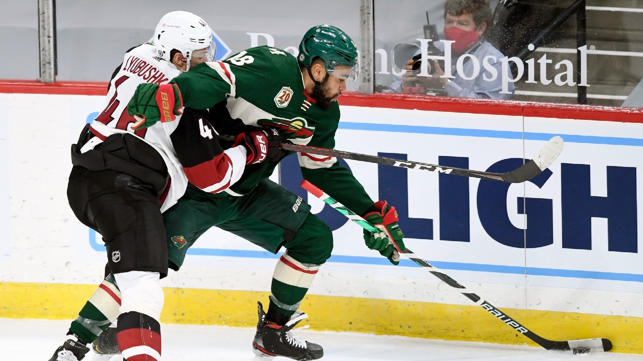 Minnesota Wild's Jordan Greenway (18) has the puck against Arizona Coyotes' Ilya Lyubushkin (46), of Russia, during the first period of an NHL hockey game Sunday, March 14, 2021, in St. Paul, Minn. (Hannah Foslien/AP)
