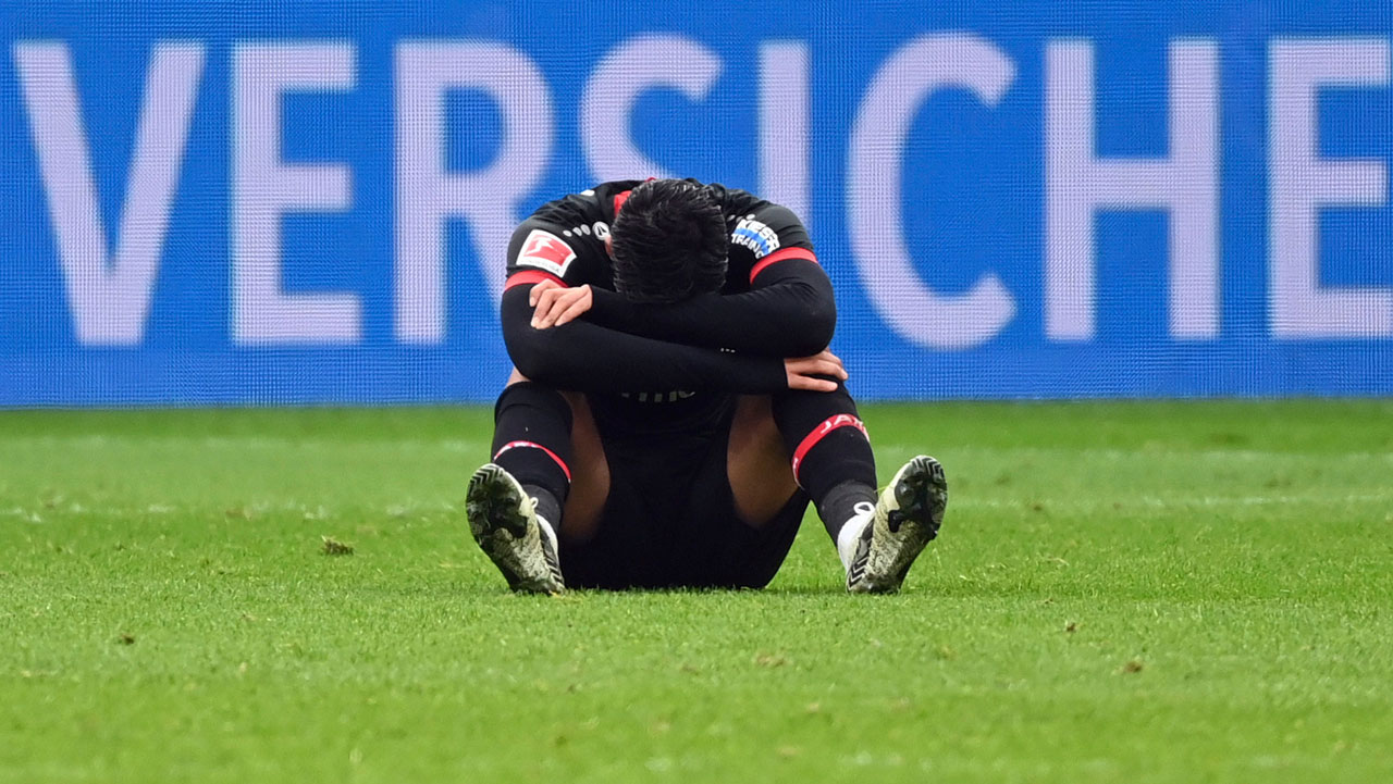 Leverkusen's Nadiem Amiri sits disappointed on the pitch after the Bundesliga soccer match. (Ina Fassbender/AP)
