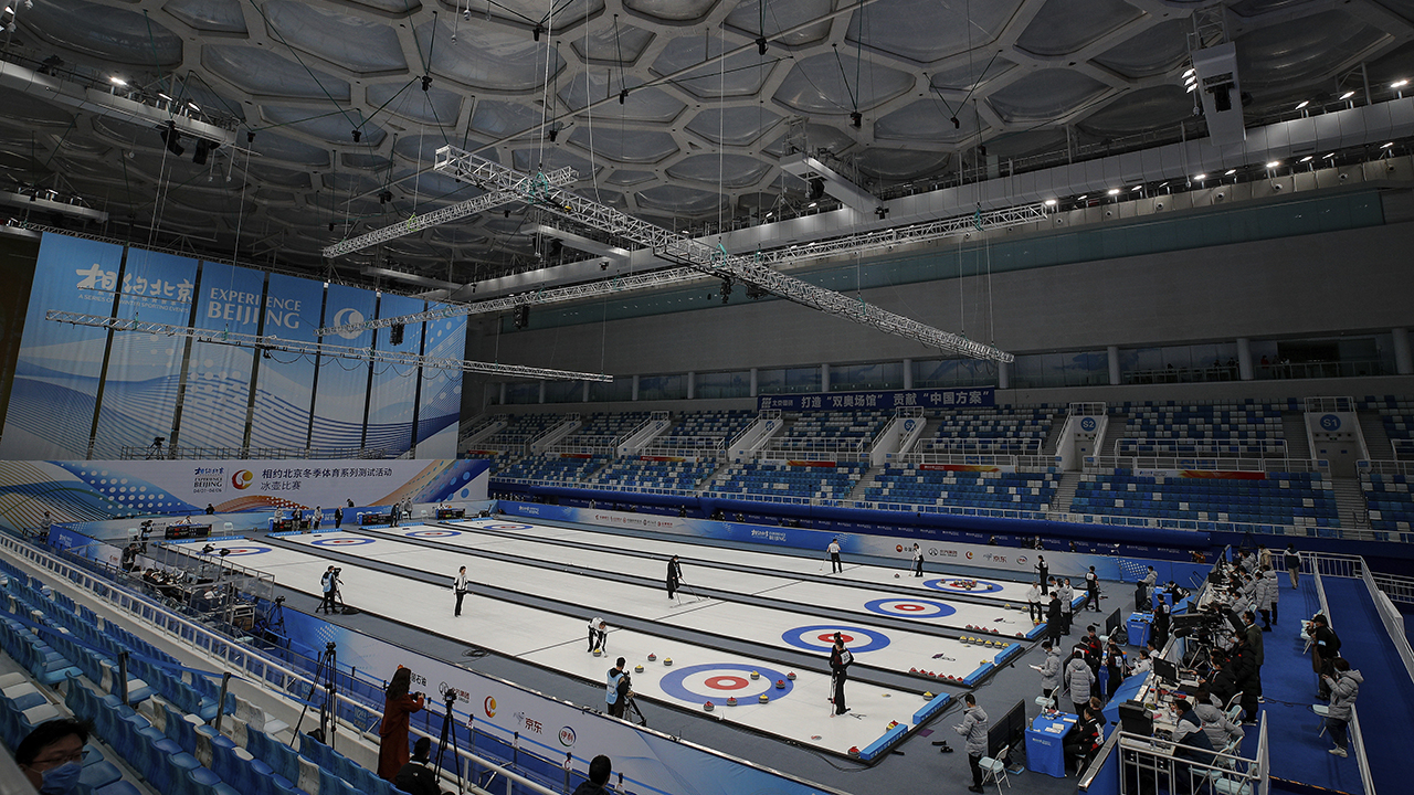 Local team players compete in a curling competition during a test event for the 2022 Beijing Winter Olympics at National Aquatic Center, also known as the "Water Cube" in Beijing. (AP Photo/Andy Wong)
