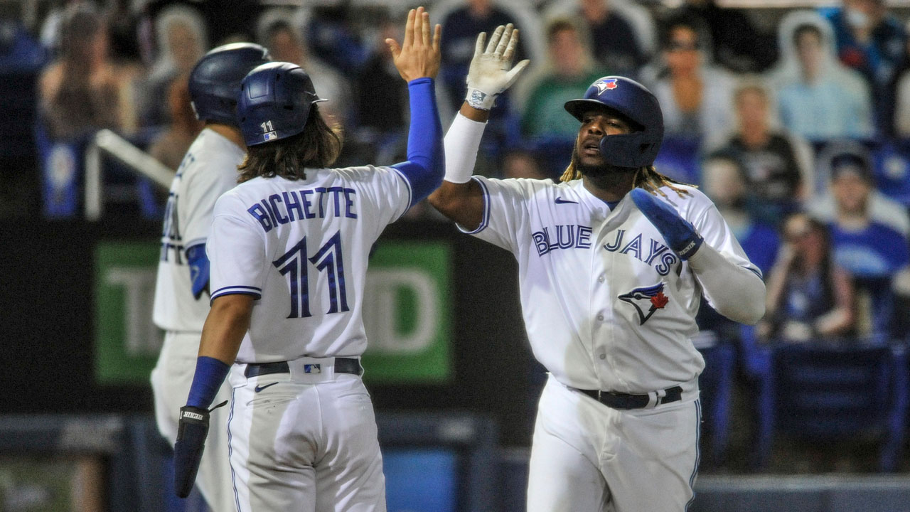 Toronto Blue Jays' Bo Bichette (11) and Vladimir Guerrero Jr. celebrate after scoring on Randal Grichuk's three-run double off Los Angeles Angels' Jose Quintana during the second inning of a baseball game Saturday, April 10, 2021, in Dunedin, Fla. (Steve Nesius/AP)