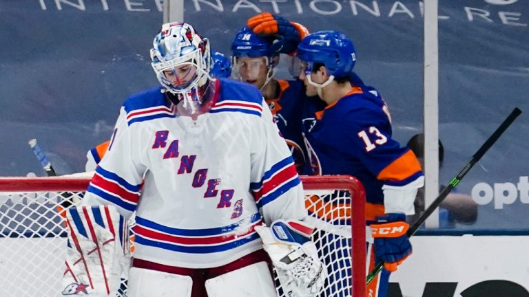 New York Rangers goaltender Igor Shesterkin looks down as New York Islanders Mathew Barzal (13) celebrates with teammates after a goal by Jordan Eberle during the third period of an NHL hockey game Tuesday, April 20, 2021, in Uniondale, N.Y. The Islanders won 6-1. (AP Photo/Frank Franklin II)