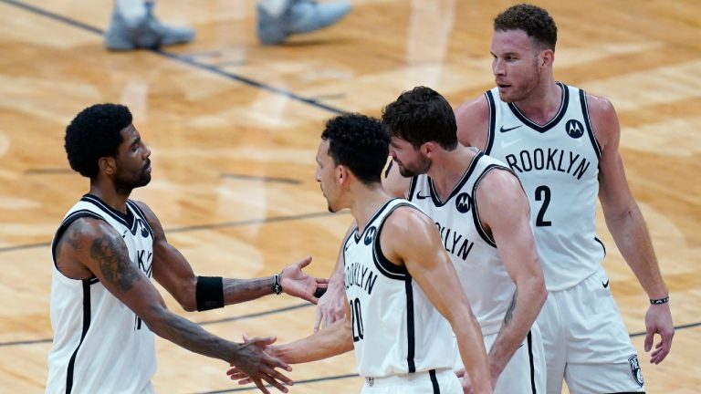 Brooklyn Nets guard Kyrie Irving, left, celebrates with teammates guard Landry Shamet (20), forward Joe Harris and forward Blake Griffin (2) in the second half of an NBA basketball game against the New Orleans Pelicans in New Orleans, Tuesday, April 20, 2021. The Nets won 134-129. (AP Photo/Gerald Herbert)