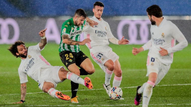 Real Madrid's Marcelo, left, vies for the ball with Betis' Aitor Ruibal, second left, during the Spanish La Liga soccer match between Real Madrid and Betis at the Alfredo di Stefano stadium in Madrid, Spain, Saturday, April 24, 2021. (AP Photo/Bernat Armangue)