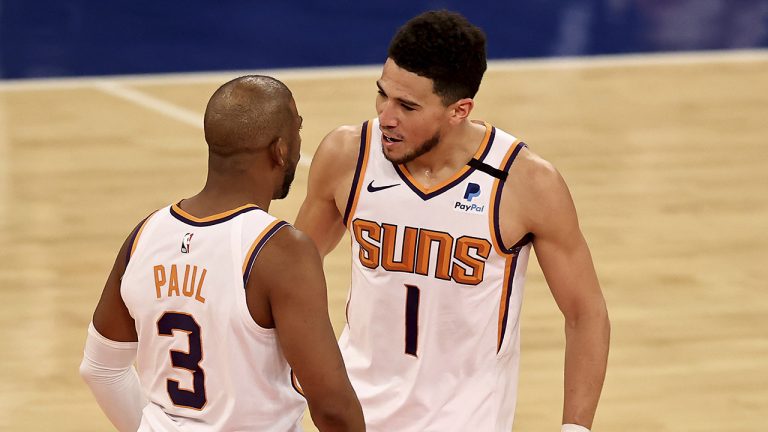 Chris Paul celebrates with teammate Devin Booker. (Elsa/Pool Photo via AP)
