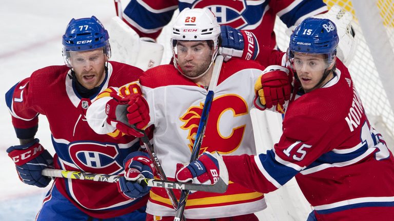 Montreal Canadiens' Brett Kulak (77) and Canadiens' Jesperi Kotkaniemi (15) tie up Calgary Flames' Dillon Dube (29) during first period NHL hockey action Wednesday, April 14, 2021 in Montreal. THE CANADIAN PRESS/Ryan Remiorz