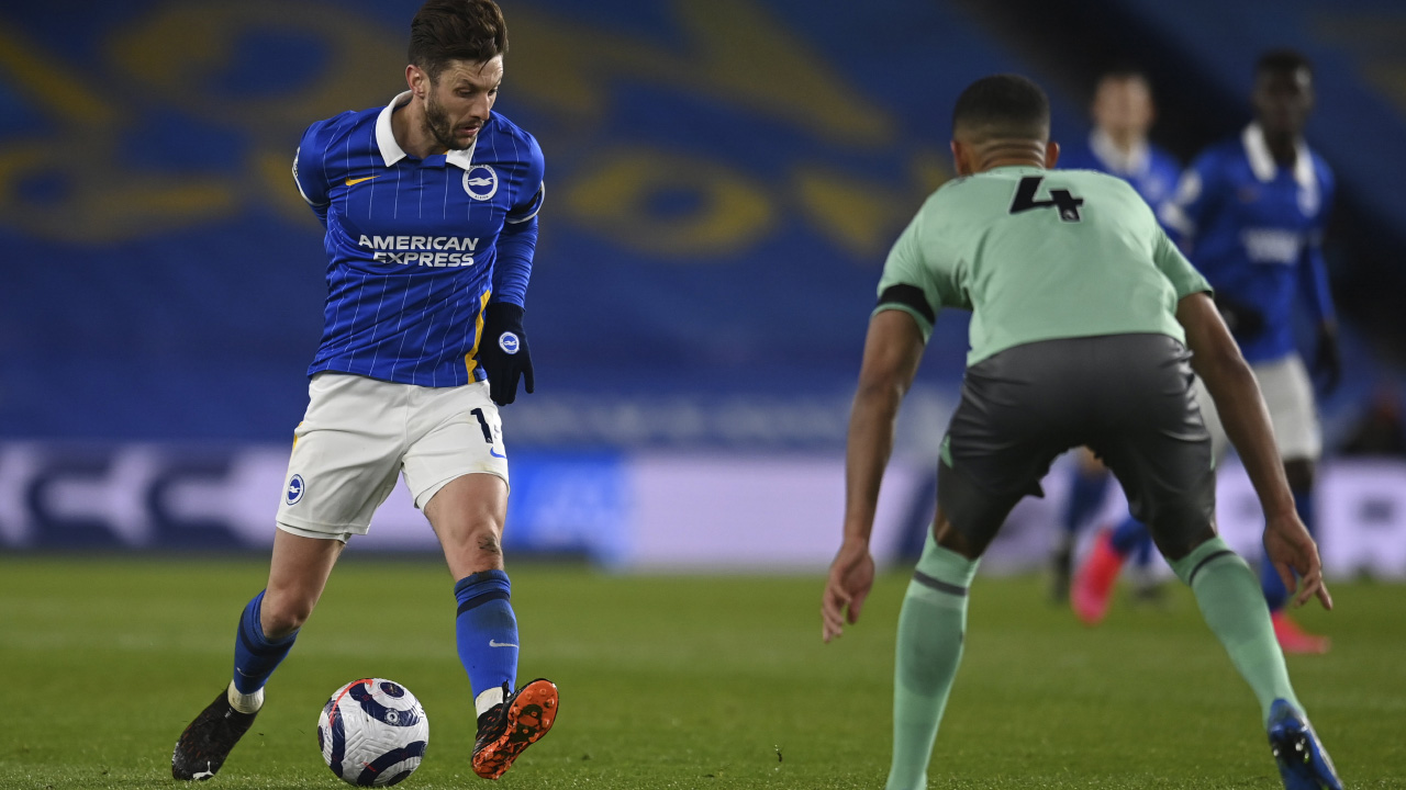 Brighton's Adam Lallana, left, is challenged by Everton's Mason Holgate during the English Premier League soccer match between Brighton and Everton at the Falmer Stadium in Brighton, England, Monday, April 12, 2021. (Glyn Kirk/AP)