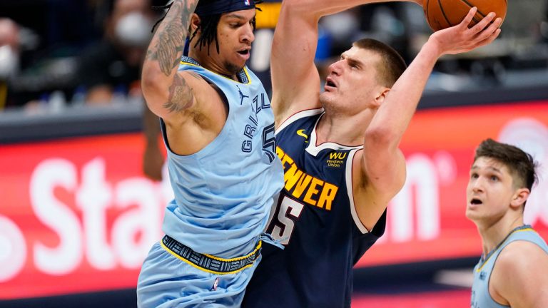 Denver Nuggets center Nikola Jokic, right, goes up to shoot as Memphis Grizzlies forward Brandon Clarke defends in the second half of an NBA basketball game. (David Zalubowski/AP)