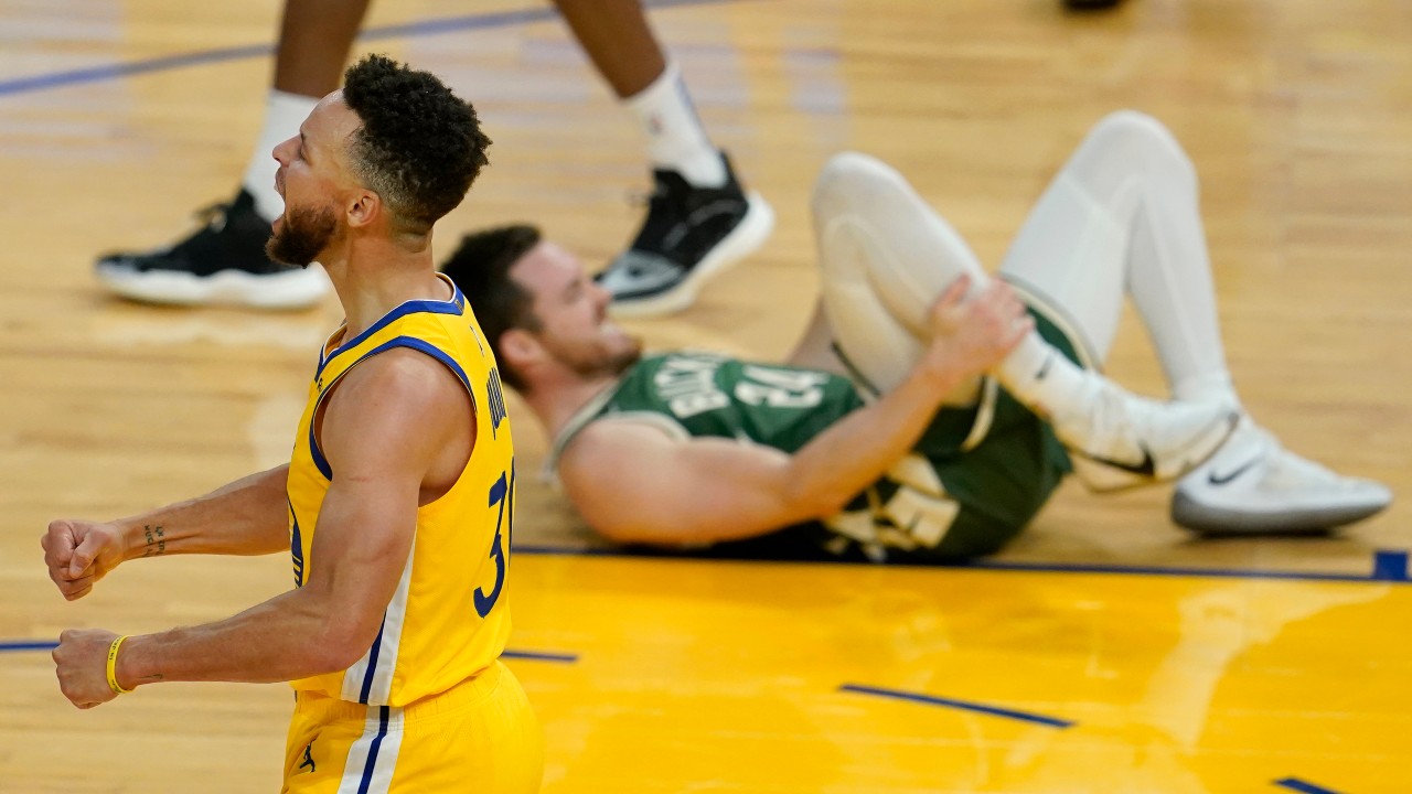 Golden State Warriors guard Stephen Curry, foreground, celebrates near Milwaukee Bucks guard Pat Connaughton after the Warriors defeated the Milwaukee Bucks in an NBA basketball game in San Francisco, Tuesday, April 6, 2021. (Jeff Chiu / AP)
