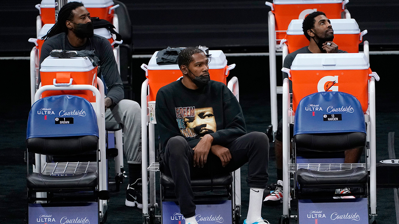 Brooklyn Nets DeAndre Jordan, left, Kevin Durant, centre, and Kyrie Irving watch their teammates play the Sacramento King during the second half in Sacramento, Calif., Monday, Feb. 15, 2021. (Rich Pedroncelli/AP)