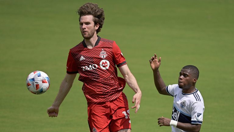 Toronto FC forward Patrick Mullins (13) and Vancouver Whitecaps forward Deiber Caicedo (7) compete for a ball during the first half of an MLS soccer match, Saturday, April 24, 2021, in Orlando, Fla. (Phelan M. Ebenhack/AP)