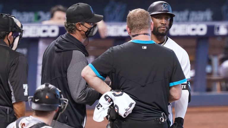 Miami Marlins manager Don Mattingly, center, and a trainer talk to batter Starling Marte before escorting him back to the dugout during the ninth inning of a baseball game against the San Francisco Giants. (Marta Lavandier/AP)