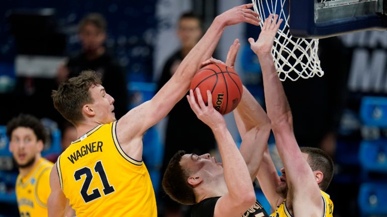 Florida State center Balsa Koprivica, center, shoots between Michigan guard Franz Wagner (21) and center Hunter Dickinson, right, during the second half of a Sweet 16 game in the NCAA men's college basketball tournament at Bankers Life Fieldhouse, Sunday, March 28, 2021, in Indianapolis. (AP Photo/Jeff Roberson)
