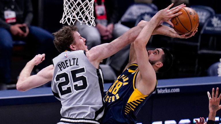 San Antonio Spurs center Jakob Poeltl, left, fouls Indiana Pacers center Goga Bitadze, right, during the second half of an NBA basketball game in Indianapolis, Monday, April 19, 2021. (AP Photo/Michael Conroy)