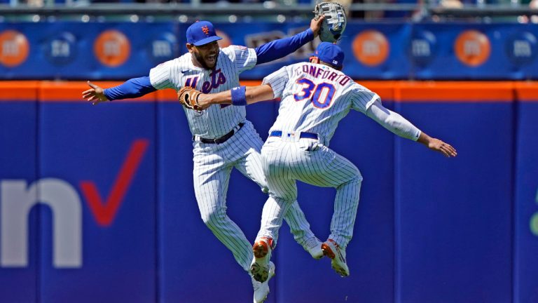 New York Mets left fielder Dominic Smith (2) and right fielder Michael Conforto (30) celebrate at the conclusion of a baseball game against the Baltimore Orioles, Wednesday, May 12, 2021, in New York. The Mets defeated the Orioles 7-1. (AP Photo/Kathy Willens)