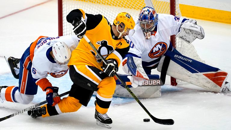 Pittsburgh Penguins' Sidney Crosby, center, cannot get his stick on the puck in front of New York Islanders goaltender Ilya Sorokinin, right, with Islanders' Ryan Pulock (6) defending during the first period of Game 1 of an NHL hockey Stanley Cup first-round playoff series in Pittsburgh, Sunday, May 16, 2021. (Gene J. Puskar/AP)