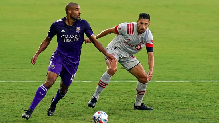 Orlando City forward Tesho Akindele, left, looks to pass the ball as Toronto FC defender Omar Gonzalez defends during the first half of an MLS soccer match, Saturday, May 22, 2021, in Orlando, Fla. (John Raoux/AP)